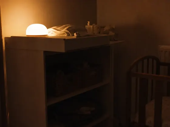 nursery, folded blanket, lamp on a shelf