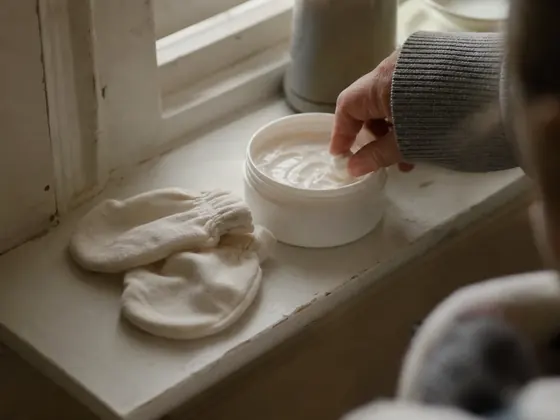 emollient pot and cotton mittens on a shelf