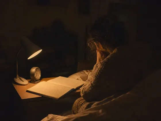clock and a notebook on a bedside table