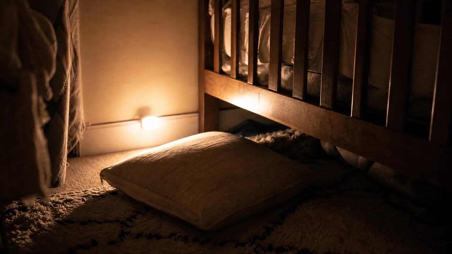 floor cushion beside a cot, night light