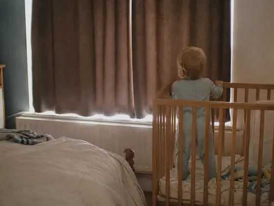 cot in a darkened daytime room