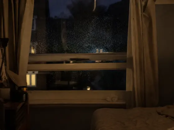 bedroom window at night, rain on the glass